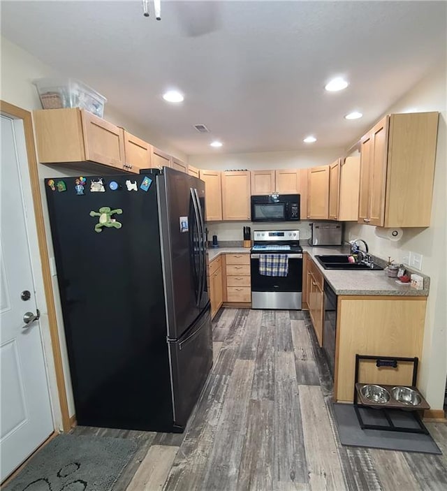 1525 Duncan St, Saint Joseph, MO 64503 - kitchen featuring stainless steel electric range oven, freestanding refrigerator, black microwave, light brown cabinets, and a sink