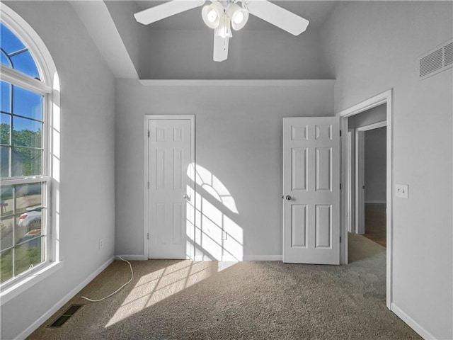 18100 E 11th Terrace Ct N, Independence, MO 64056 - empty room featuring plenty of natural light, carpet flooring, a ceiling fan, and a towering ceiling