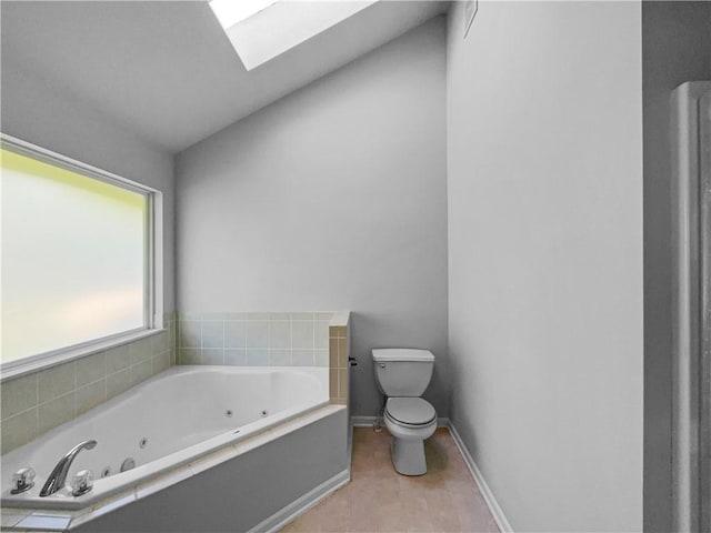 18100 E 11th Terrace Ct N, Independence, MO 64056 - bathroom with a skylight, a tub with jets, toilet, baseboards, and tile patterned flooring