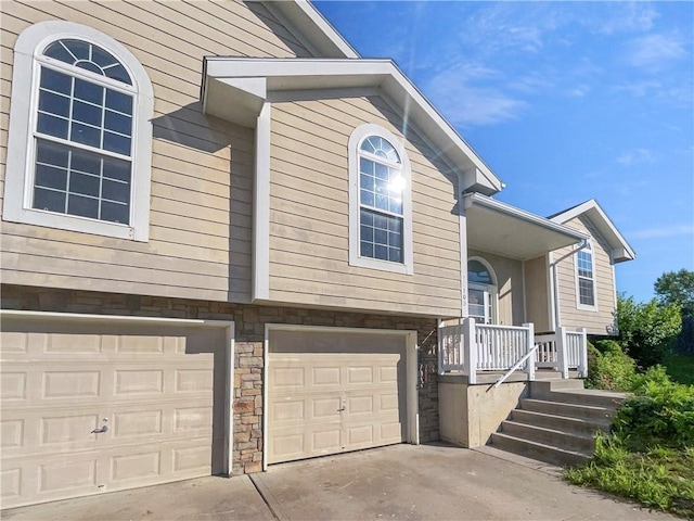 18100 E 11th Terrace Ct N, Independence, MO 64056 - view of home's exterior featuring an attached garage, stone siding, and concrete driveway