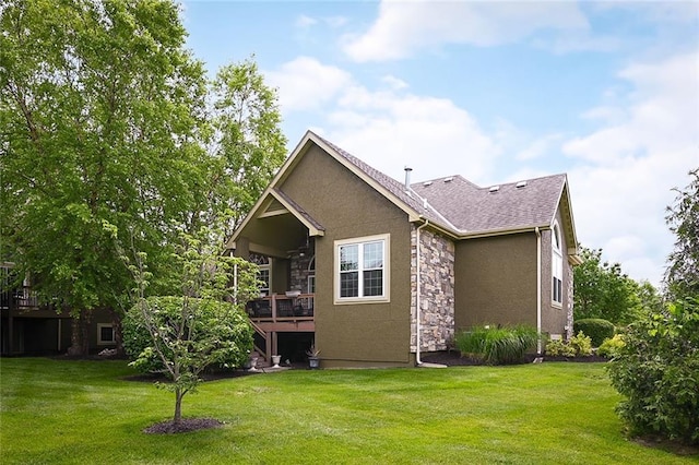 16904 S Bradley Dr, Olathe, KS 66062 - back of house featuring stone siding, a lawn, a deck, and stucco siding