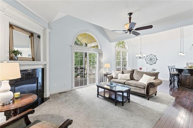 16904 S Bradley Dr, Olathe, KS 66062 - living room featuring ceiling fan, lofted ceiling, a chandelier, and dark wood-style flooring