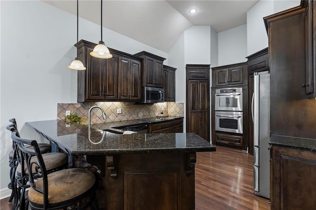 16904 S Bradley Dr, Olathe, KS 66062 - kitchen featuring black appliances, a peninsula, dark brown cabinetry, dark wood-style floors, and dark stone counters