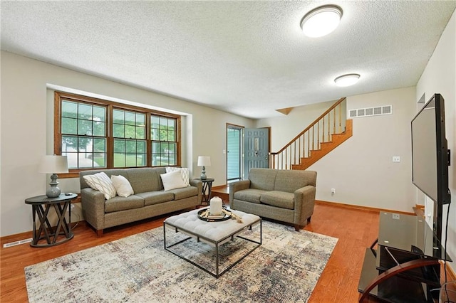 8025 Woodstone St, Lenexa, KS 66219 - living area featuring a textured ceiling, wood finished floors, and stairs
