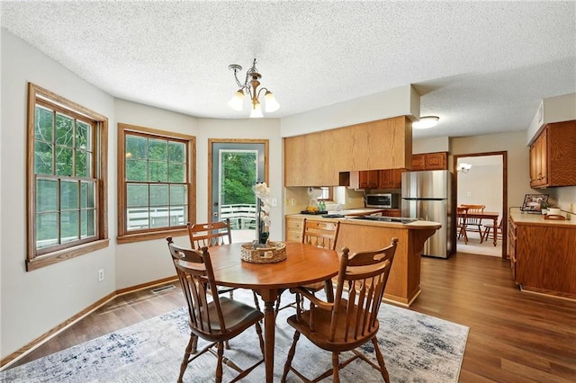 8025 Woodstone St, Lenexa, KS 66219 - dining room featuring a chandelier, dark wood-type flooring, and a textured ceiling