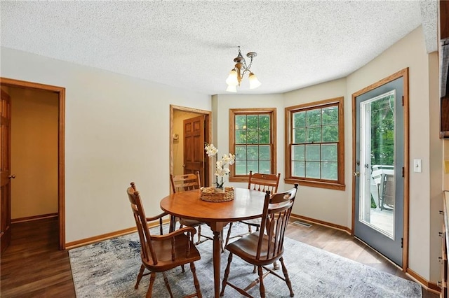 8025 Woodstone St, Lenexa, KS 66219 - dining room featuring a chandelier, wood finished floors, and a textured ceiling