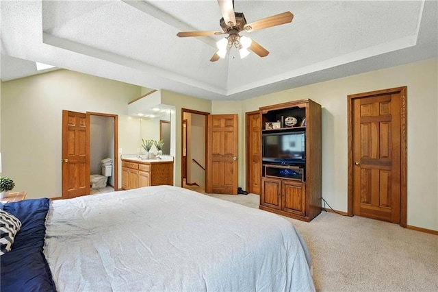 8025 Woodstone St, Lenexa, KS 66219 - bedroom with a tray ceiling, light colored carpet, ensuite bathroom, ceiling fan, and a textured ceiling