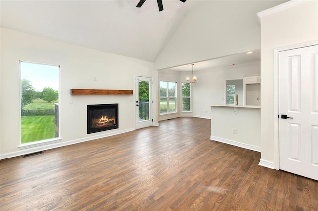 20105 Crestone St, Spring Hill, KS 66083 - unfurnished living room with a ceiling fan, a chandelier, a glass covered fireplace, high vaulted ceiling, and dark wood-style flooring