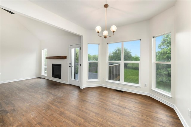 20105 Crestone St, Spring Hill, KS 66083 - unfurnished living room featuring plenty of natural light, a chandelier, dark wood finished floors, and a glass covered fireplace