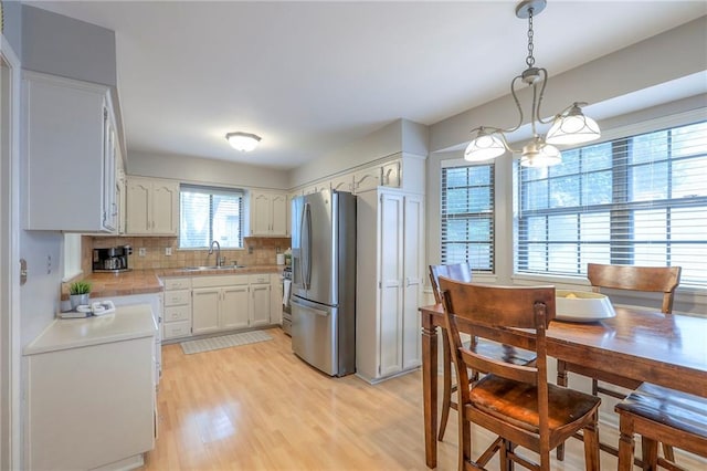 15005 W 94th St, Lenexa, KS 66215 - kitchen with appliances with stainless steel finishes, light countertops, backsplash, and light wood finished floors
