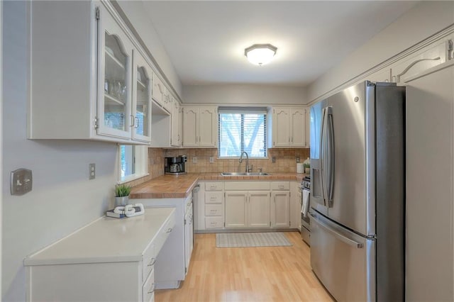 15005 W 94th St, Lenexa, KS 66215 - kitchen with appliances with stainless steel finishes, light countertops, tasteful backsplash, and light wood-style floors