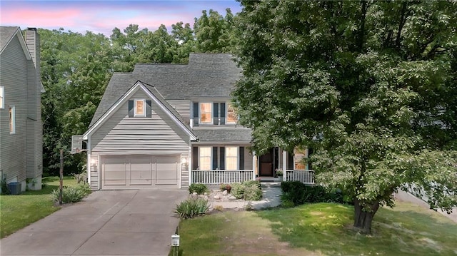 7642 N Atkins Pl, Kansas City, MO 64152 - view of front of home with driveway, a porch, a garage, and a yard