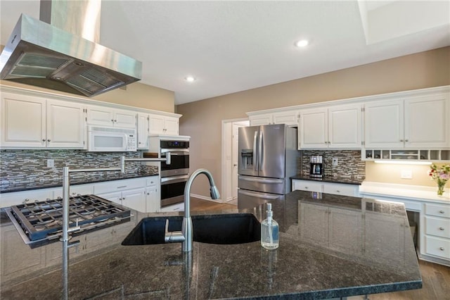 7642 N Atkins Pl, Kansas City, MO 64152 - kitchen with wall chimney range hood, appliances with stainless steel finishes, white cabinetry, tasteful backsplash, and recessed lighting