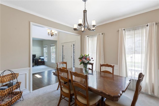 7642 N Atkins Pl, Kansas City, MO 64152 - dining room featuring a chandelier, light colored carpet, ornamental molding, and a wainscoted wall