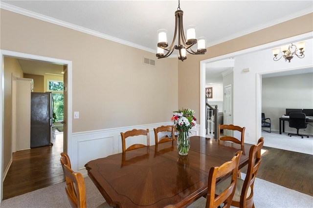 7642 N Atkins Pl, Kansas City, MO 64152 - dining room featuring a chandelier, wood finished floors, ornamental molding, and a wainscoted wall