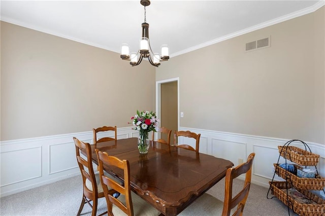 7642 N Atkins Pl, Kansas City, MO 64152 - dining room with a chandelier, light carpet, wainscoting, crown molding, and a decorative wall