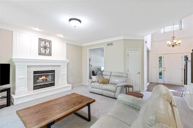 7642 N Atkins Pl, Kansas City, MO 64152 - living area featuring light carpet, a chandelier, crown molding, a tiled fireplace, and a textured ceiling