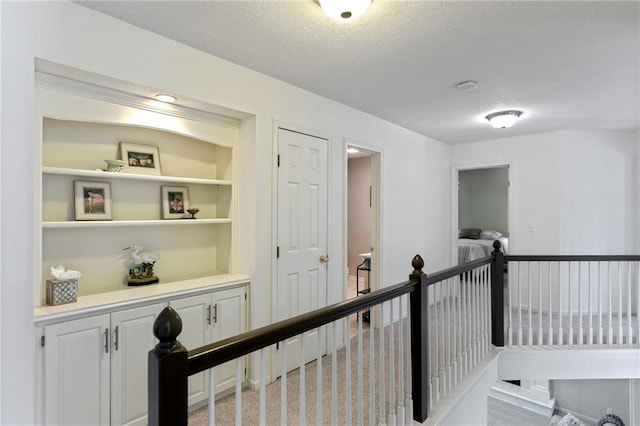 7642 N Atkins Pl, Kansas City, MO 64152 - hallway featuring an upstairs landing and a textured ceiling