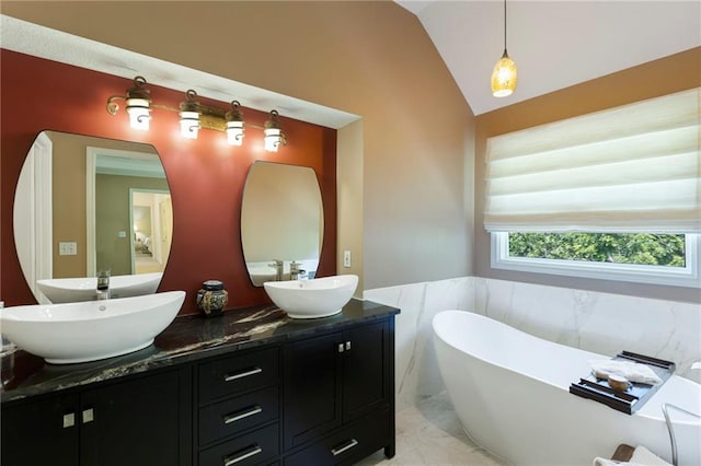 7642 N Atkins Pl, Kansas City, MO 64152 - full bathroom with a soaking tub, double vanity, vaulted ceiling, a wainscoted wall, and marble finish floors