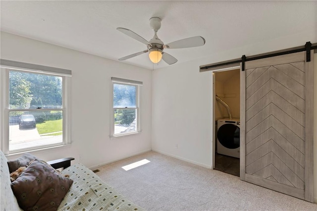 7642 N Atkins Pl, Kansas City, MO 64152 - living area featuring washer / dryer, a barn door, light colored carpet, and a ceiling fan