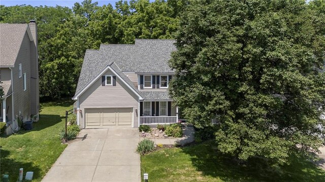 7642 N Atkins Pl, Kansas City, MO 64152 - view of front facade featuring concrete driveway, a garage, a front yard, a porch, and roof with shingles