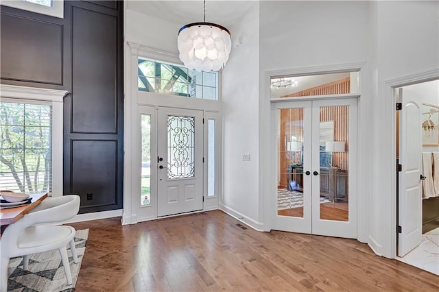 16821 Goddard St, Overland Park, KS 66221 - entryway with a towering ceiling, healthy amount of natural light, a chandelier, french doors, and wood finished floors