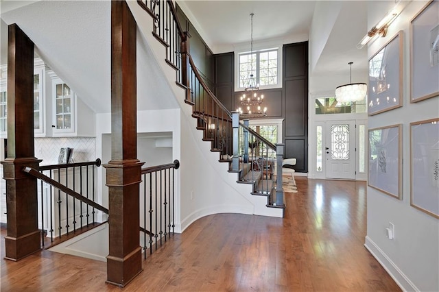 16821 Goddard St, Overland Park, KS 66221 - foyer featuring a chandelier, a high ceiling, wood finished floors, decorative columns, and baseboards