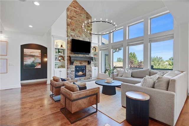 16821 Goddard St, Overland Park, KS 66221 - living room with high vaulted ceiling, healthy amount of natural light, wood finished floors, a stone fireplace, and built in shelves