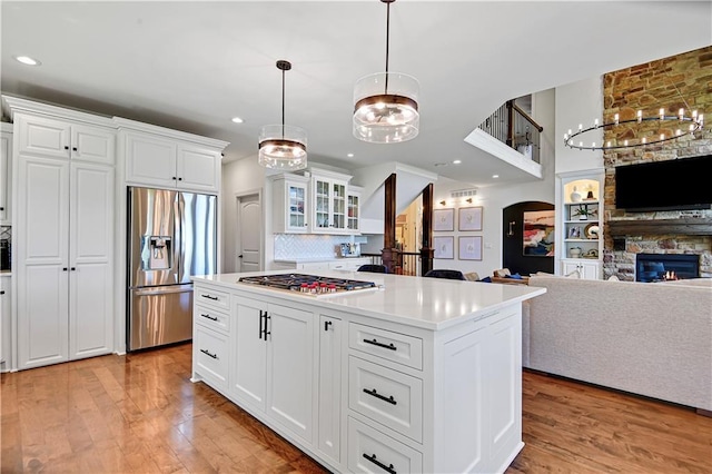 16821 Goddard St, Overland Park, KS 66221 - kitchen with appliances with stainless steel finishes, light wood-type flooring, open floor plan, a fireplace, and recessed lighting