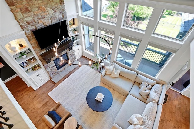 16821 Goddard St, Overland Park, KS 66221 - living room featuring a fireplace, wood finished floors, plenty of natural light, and a high ceiling