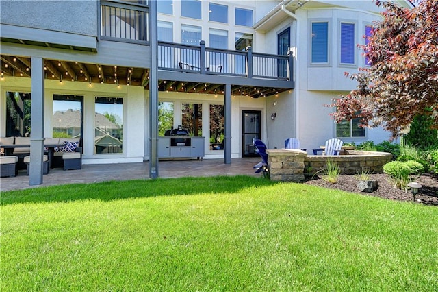 16821 Goddard St, Overland Park, KS 66221 - rear view of house featuring a patio, a lawn, stucco siding, and a balcony
