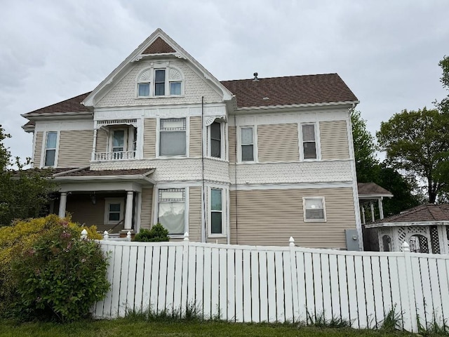 308 E Arrow St, Marshall, MO 65340 - view of front of property with a fenced front yard, a balcony, and roof with shingles