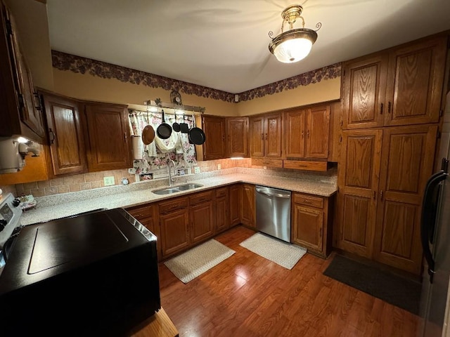 308 E Arrow St, Marshall, MO 65340 - kitchen featuring electric range, stainless steel dishwasher, a sink, brown cabinetry, and light wood-style flooring