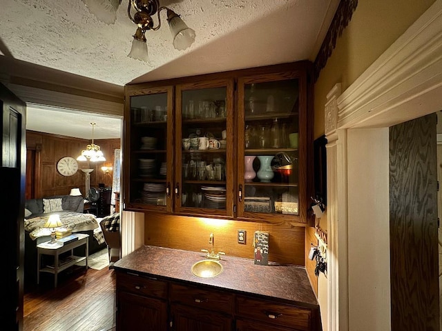 308 E Arrow St, Marshall, MO 65340 - kitchen with dark wood-type flooring, glass insert cabinets, dark brown cabinetry, and a sink