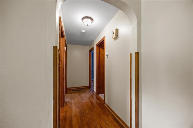 6608 N Edison Ave, Kansas City, MO 64151 - corridor featuring wood finished floors, arched walkways, and baseboards