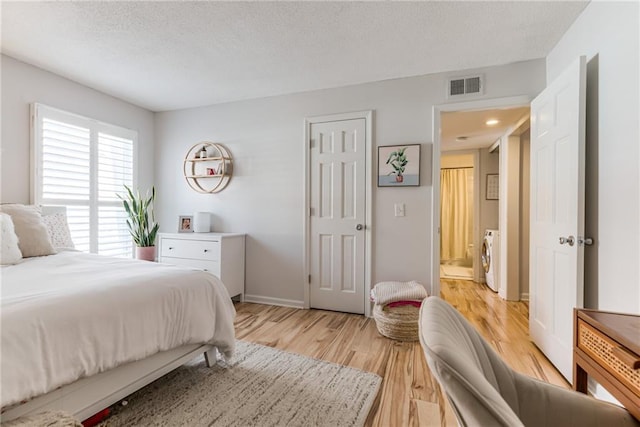 3606 Gillham Rd Unit 25, Kansas City, MO 64111 - bedroom with light wood finished floors, independent washer and dryer, baseboards, and a textured ceiling