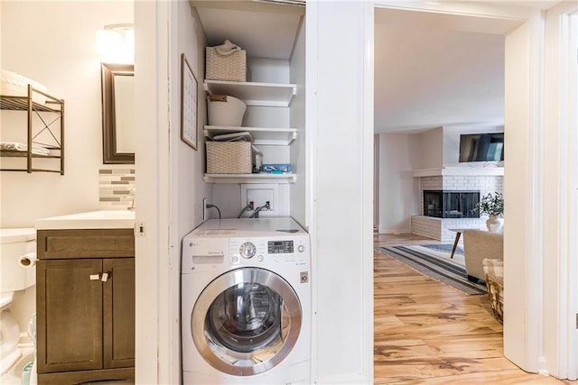 3606 Gillham Rd Unit 25, Kansas City, MO 64111 - washroom with washer / clothes dryer, light wood-style floors, and a fireplace