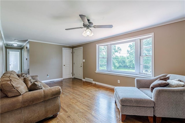2200 E 126th St, Kansas City, MO 64146 - living area with healthy amount of natural light, crown molding, baseboards, wood finished floors, and a ceiling fan