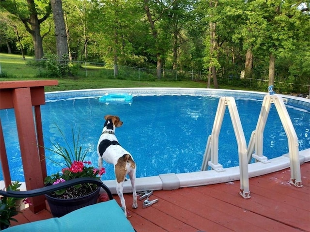 2200 E 126th St, Kansas City, MO 64146 - view of swimming pool with view of wooded area and a wooden deck