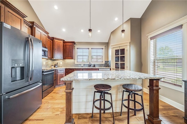12301 White Oak St, Peculiar, MO 64078 - kitchen featuring appliances with stainless steel finishes, vaulted ceiling, light wood finished floors, backsplash, and a sink