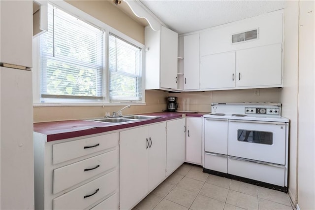 7001 Hunter St, Raytown, MO 64133 - kitchen with white appliances, a sink, light tile patterned flooring, white cabinets, and a textured ceiling