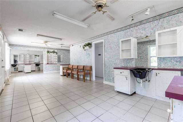 7001 Hunter St, Raytown, MO 64133 - kitchen featuring wallpapered walls, ceiling fan, open shelves, a textured ceiling, and white cabinets