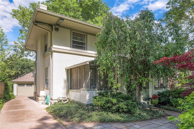 5808 Mcgee St, Kansas City, MO 64113 - view of front of property with a chimney, stucco siding, a sunroom, and a detached garage
