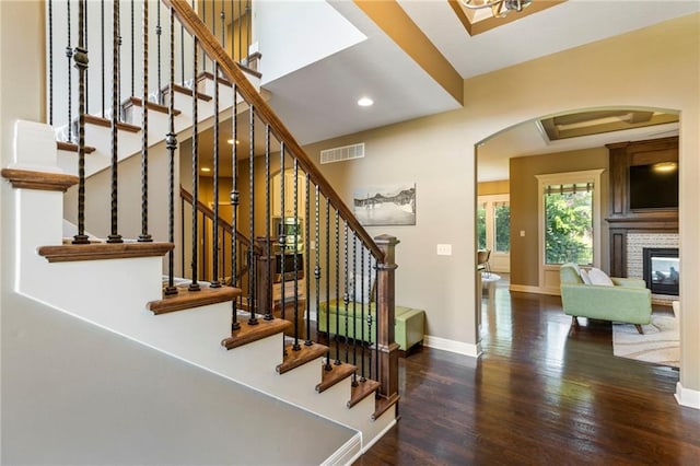 11446 S Longview Rd, Olathe, KS 66061 - stairs featuring arched walkways, wood finished floors, recessed lighting, and a brick fireplace