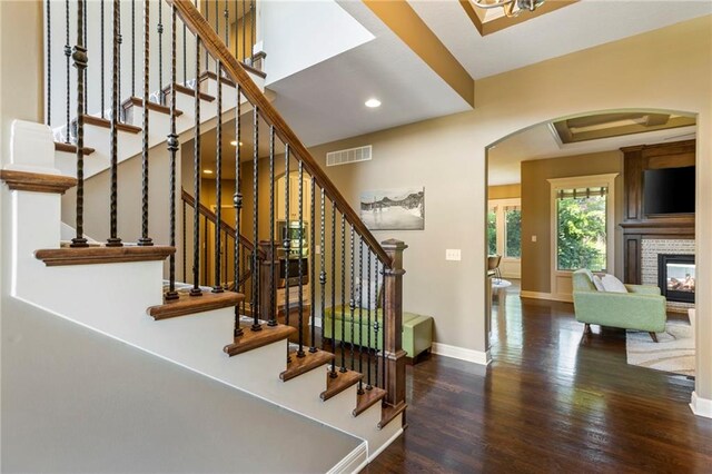 11446 S Longview Rd, Olathe, KS 66061 - stairs with arched walkways, wood finished floors, recessed lighting, and a multi sided fireplace