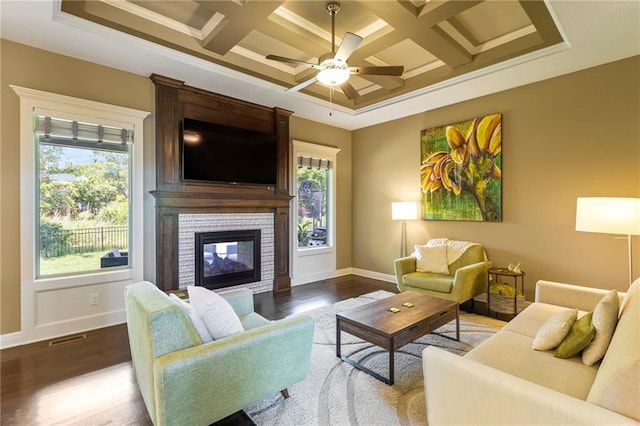 11446 S Longview Rd, Olathe, KS 66061 - living area featuring dark wood-type flooring, healthy amount of natural light, ceiling fan, coffered ceiling, and crown molding