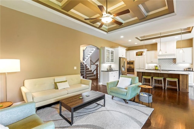 11446 S Longview Rd, Olathe, KS 66061 - living area featuring ornamental molding, coffered ceiling, a ceiling fan, dark wood-style floors, and arched walkways