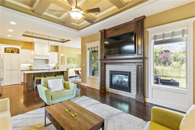11446 S Longview Rd, Olathe, KS 66061 - living area with healthy amount of natural light, a ceiling fan, dark wood-type flooring, ornamental molding, and recessed lighting