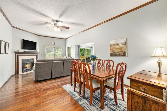 16519 E 53rd Street Ct, Independence, MO 64055 - dining room with ornamental molding, a ceiling fan, hardwood / wood-style flooring, a textured ceiling, and a tiled fireplace