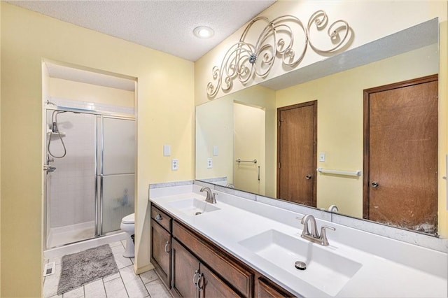 16519 E 53rd Street Ct, Independence, MO 64055 - full bathroom with toilet, double vanity, a stall shower, a textured ceiling, and tile patterned floors